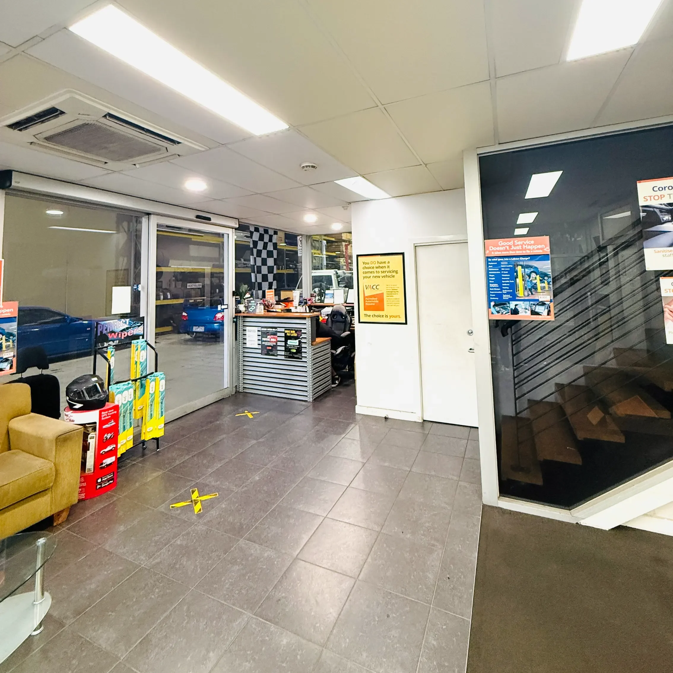 Garage Full Throttle's customer waiting area and reception in Craigieburn, with a clear view through to the workshop where vehicles are being serviced.