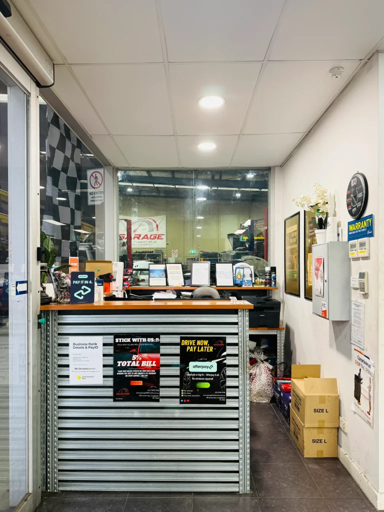 Garage Full Throttle reception counter in Craigieburn showing the customer service area with Afterpay payment options, warranty information, and a direct view through to the workshop, serving Melbourne's northern suburbs.