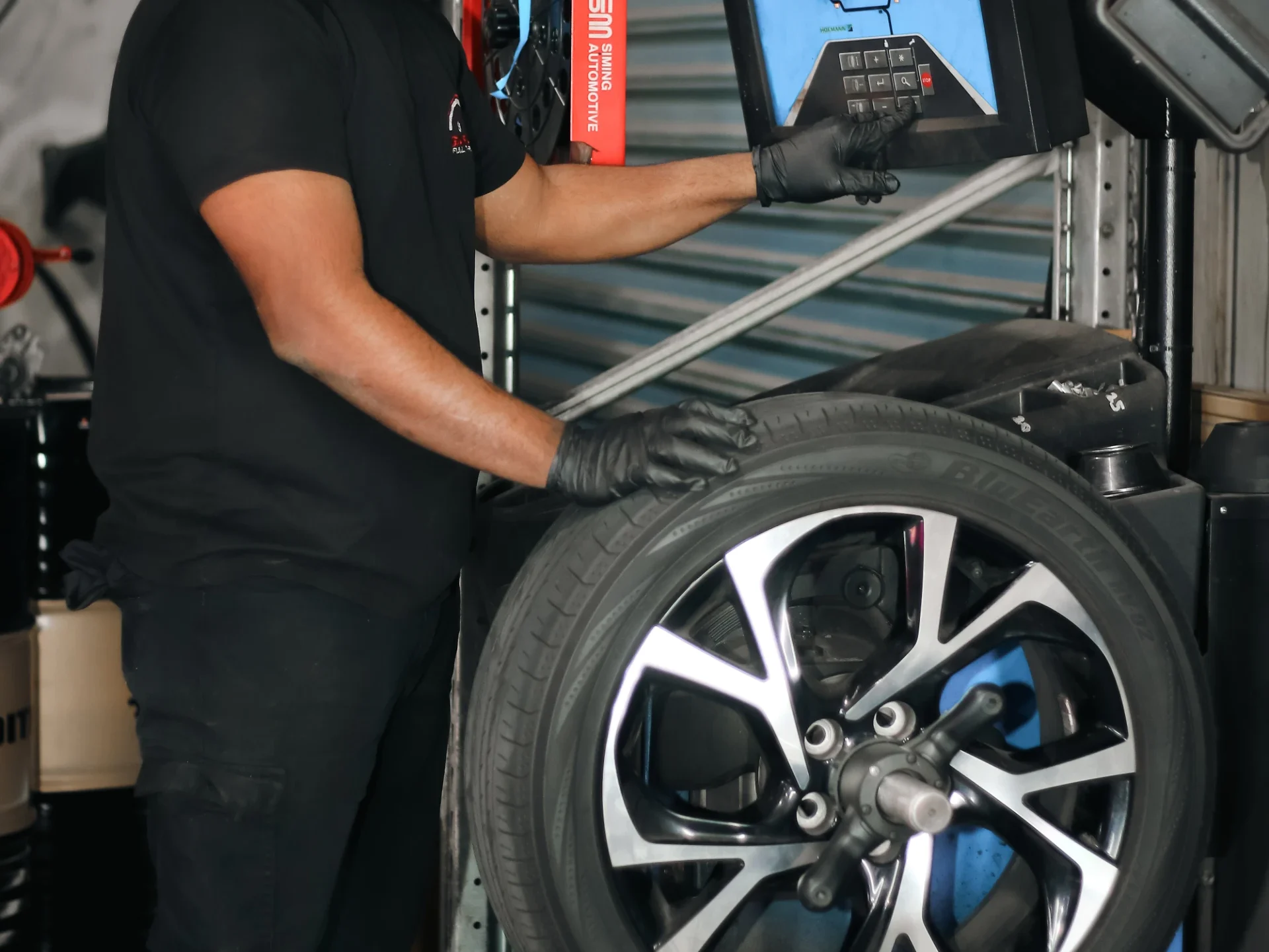 Garage Full Throttle Mechanic Doing A Tyre Service