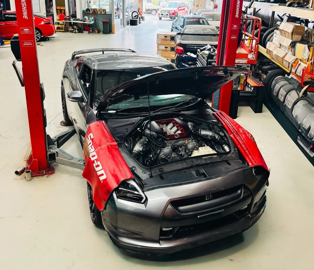 Nissan GT-R on hydraulic lift at Garage Full Throttle automotive workshop in Craigieburn showing engine bay maintenance and performance tuning service